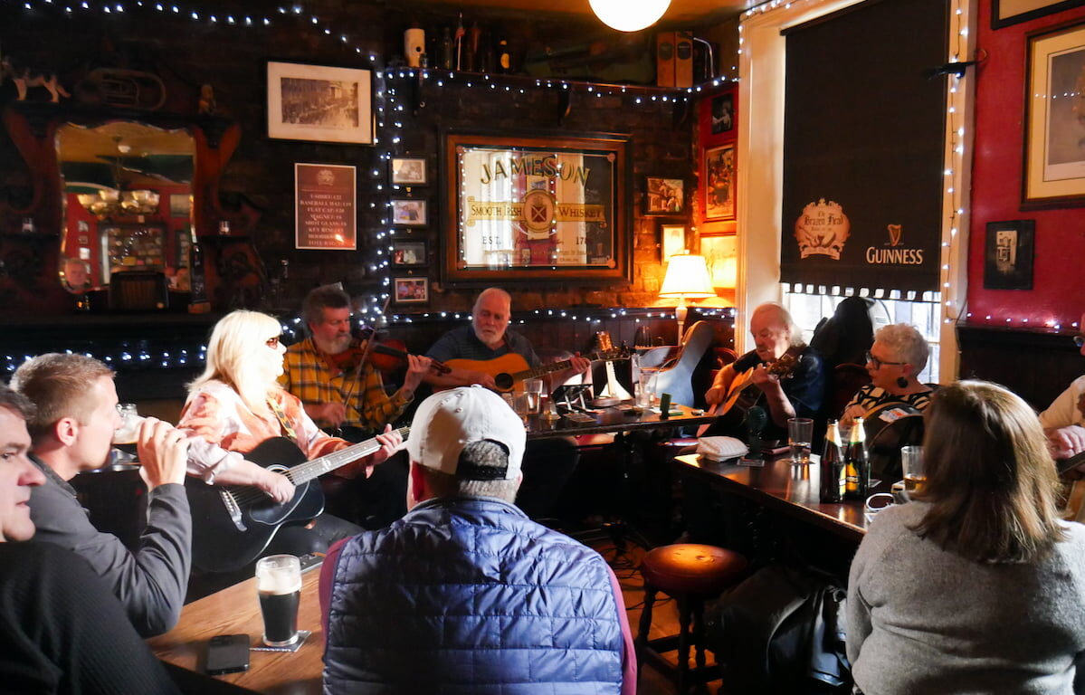 Guests enjoy live music and cosy atmosphere at the hotel pub, featuring traditional decor and warm lighting.