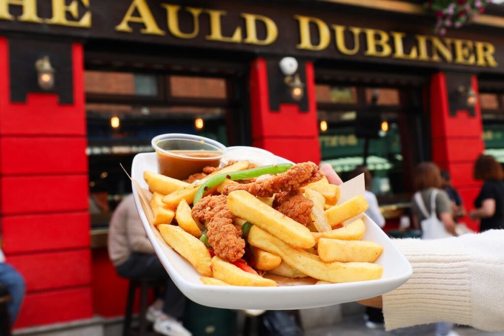 Savoury chips and crispy chicken served outside The Auld Dubliner pub, offering a welcoming dining experience.
