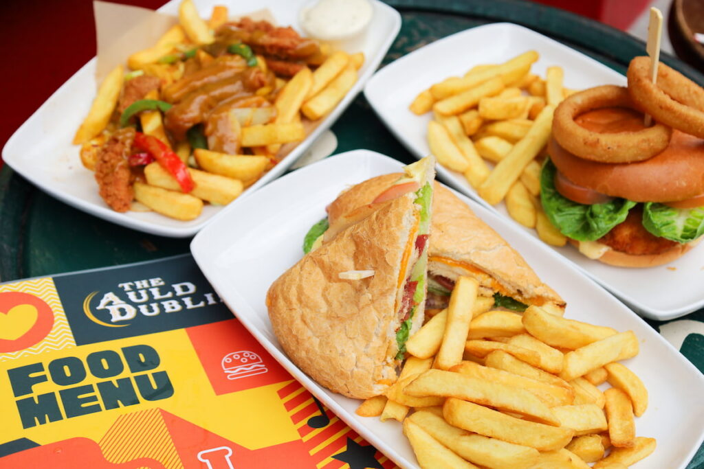 Enjoy a hearty pub meal with crispy chips, onion rings, and a fresh sandwich at The Auld Dublin. Perfect for a cosy dining experience.
