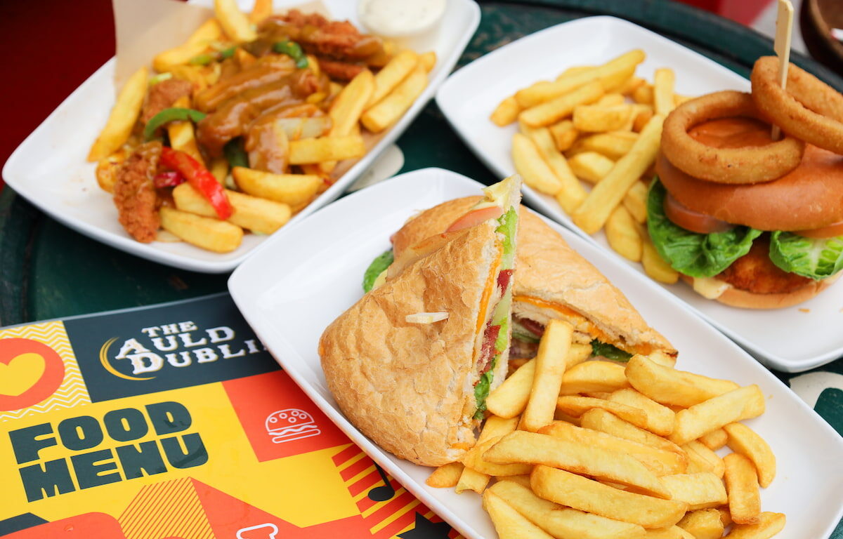 Enjoy a hearty pub meal with crispy chips, onion rings, and a fresh sandwich at The Auld Dublin. Perfect for a cosy dining experience.